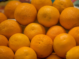 A pile of oranges sitting on top of a wooden table