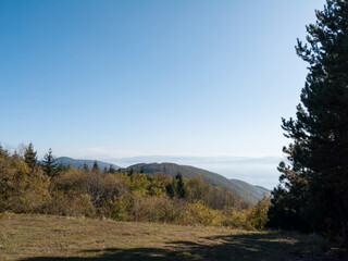 Scenic view from Kozara mountain to the valley filled with fog and smoke during a sunny day.