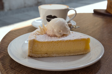 Delicious Serbian breakfast - a cup of hot cappuccino with milk foam and sweet lemon pie with vanilla ice-cream