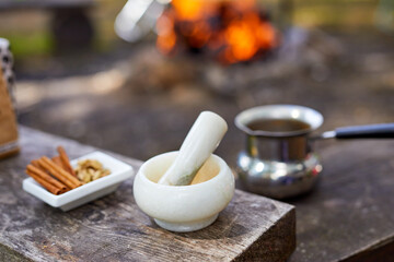 Hot drink on nature. Process of cooking coffee with spices in nature. Background - camping and forest. Active rest.