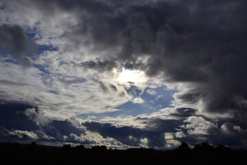 Cumulonimbus clouds at sunset over village fields. Autumn bad weather in the foothills of the Western Urals.