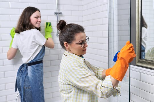 Family Mother And Teenage Daughter Cleaning Together At Home In The Bathroom