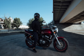 Fototapeta na wymiar Man seat on the motorcycle.Motorcyclist in black helmet on a red bike