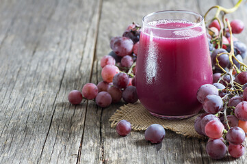 Glass of black or red grape fruit compote juice with fresh grapes, organic fruit cold drink concept, original colour