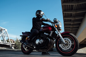 Fototapeta na wymiar Man seat on the motorcycle.Motorcyclist in black helmet on a red bike
