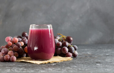 Glass of black or red grape fruit compote juice with fresh grapes, organic fruit cold drink...
