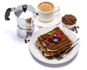 portion of Classic tiramisu dessert with raspberries and blueberries, cup of espresso and coffee maker isolated on white background with clipping path