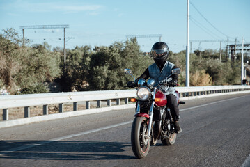 Man rides a motorcycle in the city.Motorcyclist riding a bike during the day on the road © bo.kvk