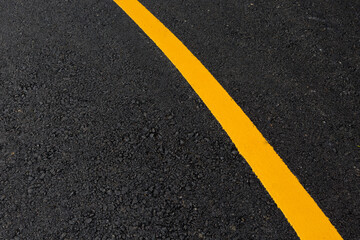 Fototapeta premium Yellow line on asphalt road texture background