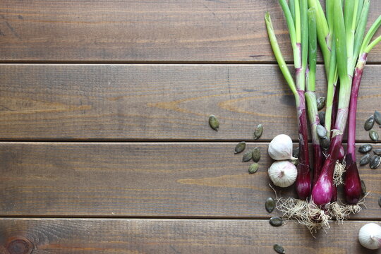 a group of spring onions on wooden background