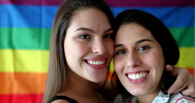 Gay pride portraits, two LGBT lesbian girlfriends smiling at camera