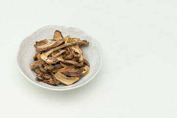 Fototapeta na wymiar dried mushrooms in a saucer, on a white background
