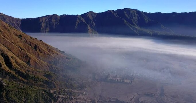 Aerial view of the Luhur Poten Temple and the batok mountain covered in fog