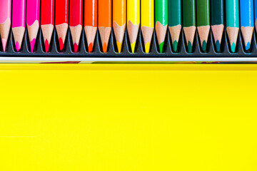 Multicolored and colorful pencils on the yellow background, stationary thing for drawing