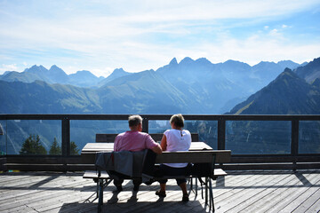 couple sitting on a bench with a Alp mountain view at Fellhorn, Oberstdorf, Bayern, Germany
