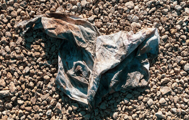 Dirty old wrinkled cloth on gravel