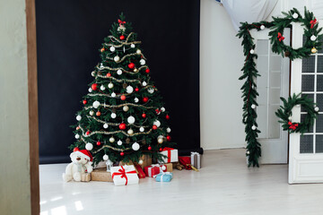 Festive room interior with stylish armchair and beautiful Christmas tree