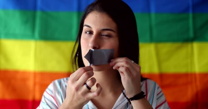 Gay woman removing duct tape from mouth, freedom of speech concept
