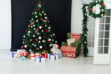 Festive room interior with stylish armchair and beautiful Christmas tree