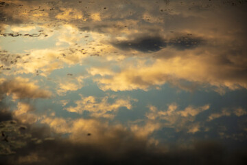 Clouds in the sky with reflection in the lake at sunset.