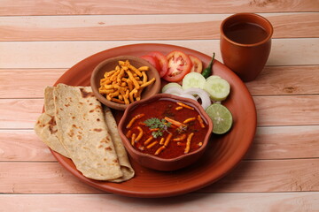 Dhaba style Sev bhaji/sabzi/curry made in tomato curry with gathiya shev, served with chapati/ roti.