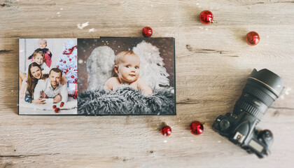 cute baby christmas angel and young family in retro photo book