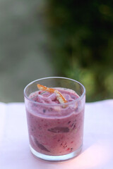 Banana and berry vegan nice cream, served in a garden. Selective focus.