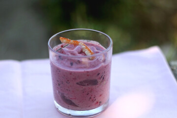 Banana and berry vegan nice cream, served in a garden. Selective focus.