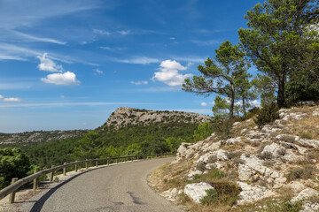 Fototapeta na wymiar Curve on the road between mountains and forest in the Vauvenargues commune natural park, Provence-Alpes-Côte d'Azur region, Bouches-du-Rhône department, France