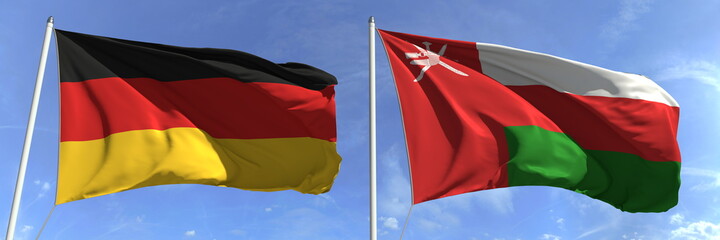 Flags of Germany and Oman on flagpoles. 3d rendering