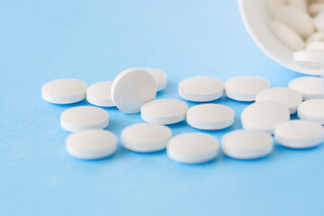 White homeopathic pills on a blue background. Close up