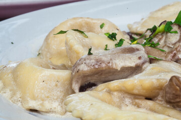 Delicious homemade ravioli filled with mushrooms and ricotta and served under sour cream sauce with porcini