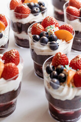 Festive cake for the birthday. Сakes with cream and berries. Desserts for adults and children on table. Festive cupcakes with chocolate and berries. Vertical photo.