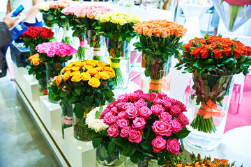 Colorful bouquets of roses on showcase of flower shop