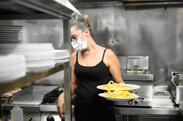 Young waitress with face protective mask working in restaurant. Coronavirus or Covid-19 concept. High quality photo