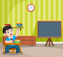 The boy studies in the school near the blackboard