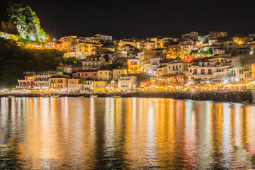 Fototapeta na wymiar Night panorama or nightscape of the city of Parga, Greece. Looking across the bay towards traditional houses and syvota castle.