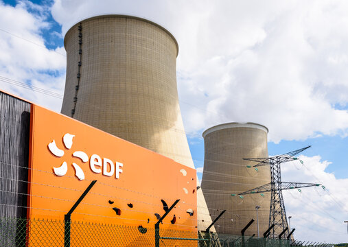 Nogent-sur-Seine, France - September 1, 2020: Low angle view of the EDF (Electricité de France) sign at the entrance of the nuclear power station of Nogent-sur-Seine and the two cooling towers.