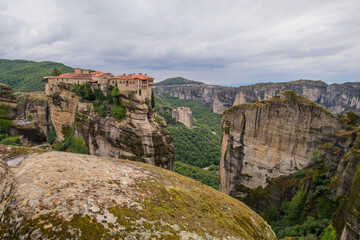 Fototapeta na wymiar Panorama of Varlaam Monastery. Beautiful scenic panoramic view, ancient traditional greek building on the top of huge stone pillar in Meteora,Thessaly, Greece, Europe on a cloudy day.