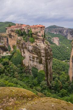Vertical photo of  Varlaam Monastery. Beautiful scenic panoramic view, ancient traditional greek building on the top of huge stone pillar in Meteora,Thessaly, Greece, Europe on a cloudy day.
