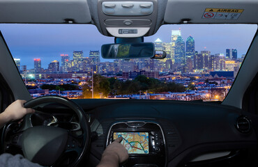 Driving while using GPS towards Philadelphia skyline at night, USA