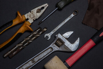 Working tools on a black background. Used and dirty work tools for home improvement or diy repair projects. Manual labor concept. 