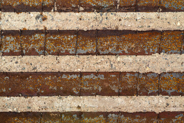 Damaged railway viaduct with cracked ceiling, visible rusty reinforcement and steel.