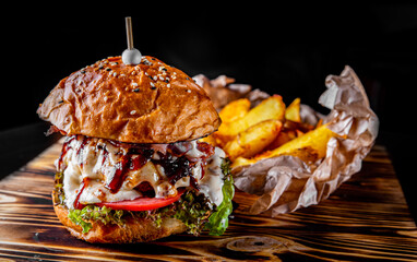 Traditional beef burger with vegetables on dark background