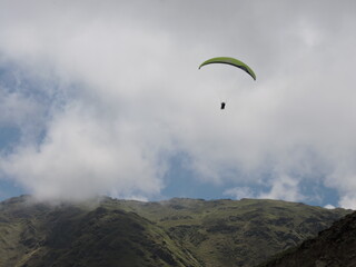 Paragliding near the clouds over mountains