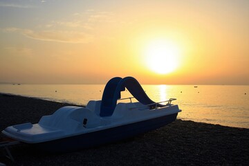 pedal boat on the seashore in the backlight