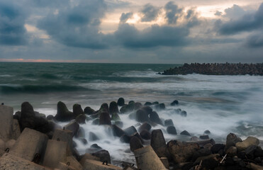 Wave breaker concrete view with sunset sky background in Glagah beach, South Java Island, Indonesia
