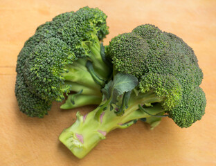 healthy broccoli and florets on wooden board