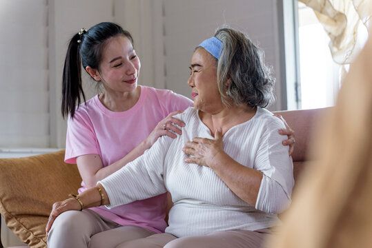 Asian Young Woman Take Care And  Support With Hug, That Make Feel Good And Smile Older Mother In Living Room. Family Concept