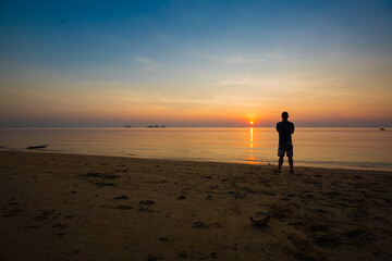 Naklejka premium Beach with sunsetview and a silhouette from a men at Ko Samui Island Thailand